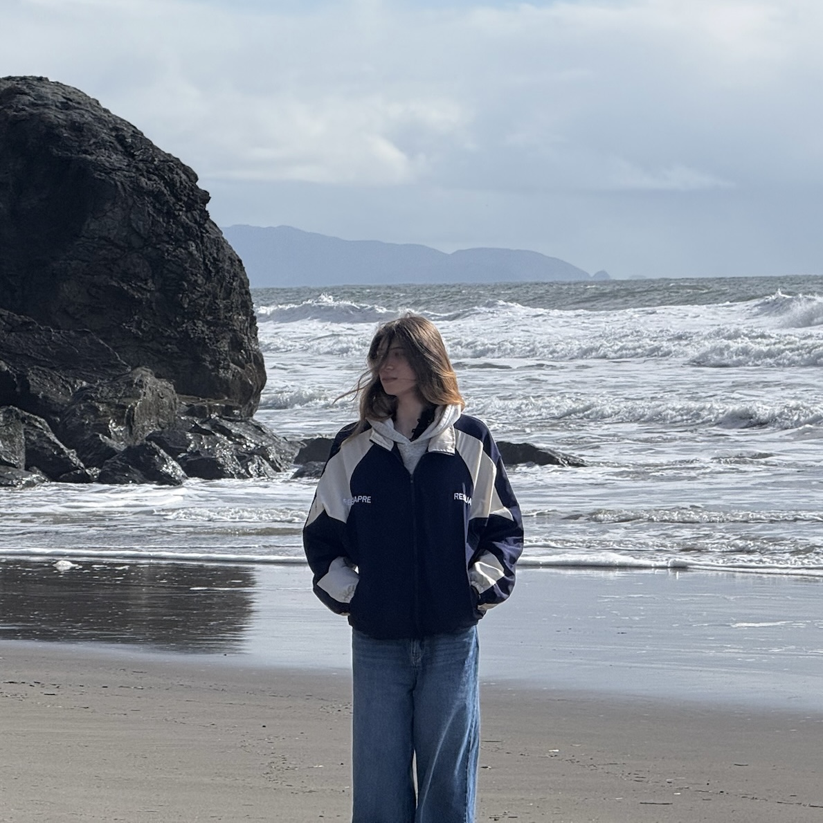 The girl standing near the ocean